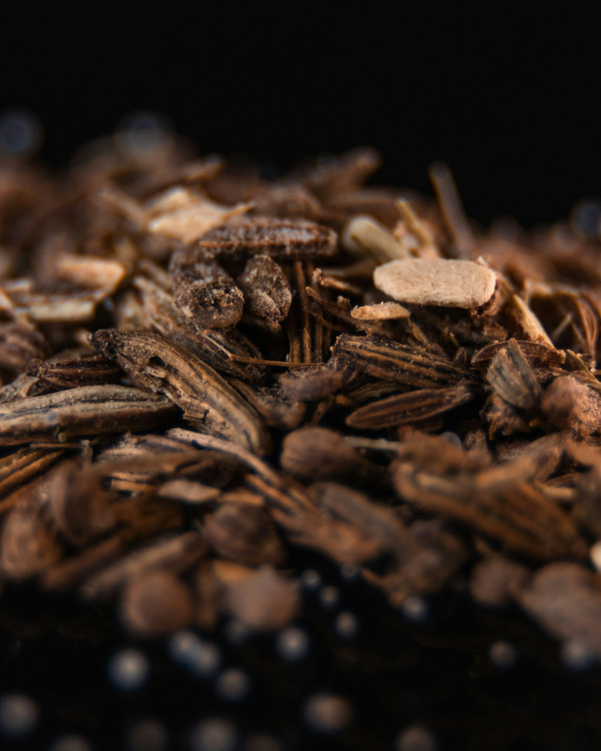 Cut dried ashwagandha root pieces on a dark surface
