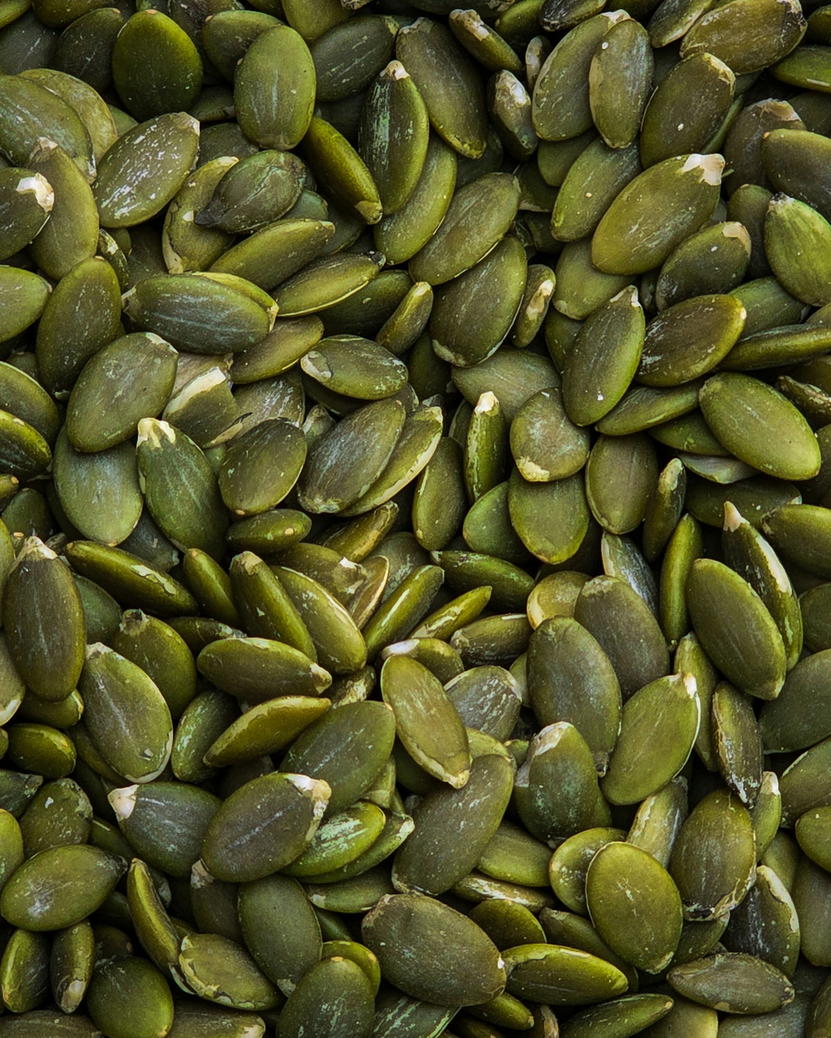 Raw green pumpkin seeds filling the frame